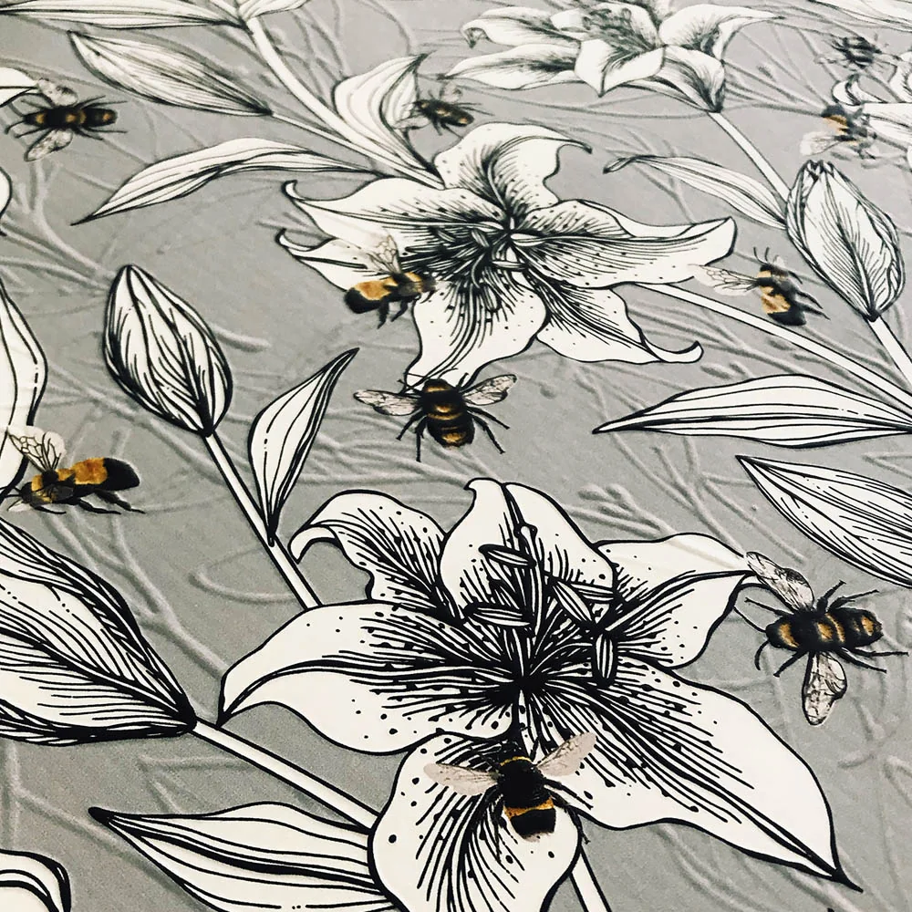 Embossed printed wallcovering with lilies and bees, relief catching the light