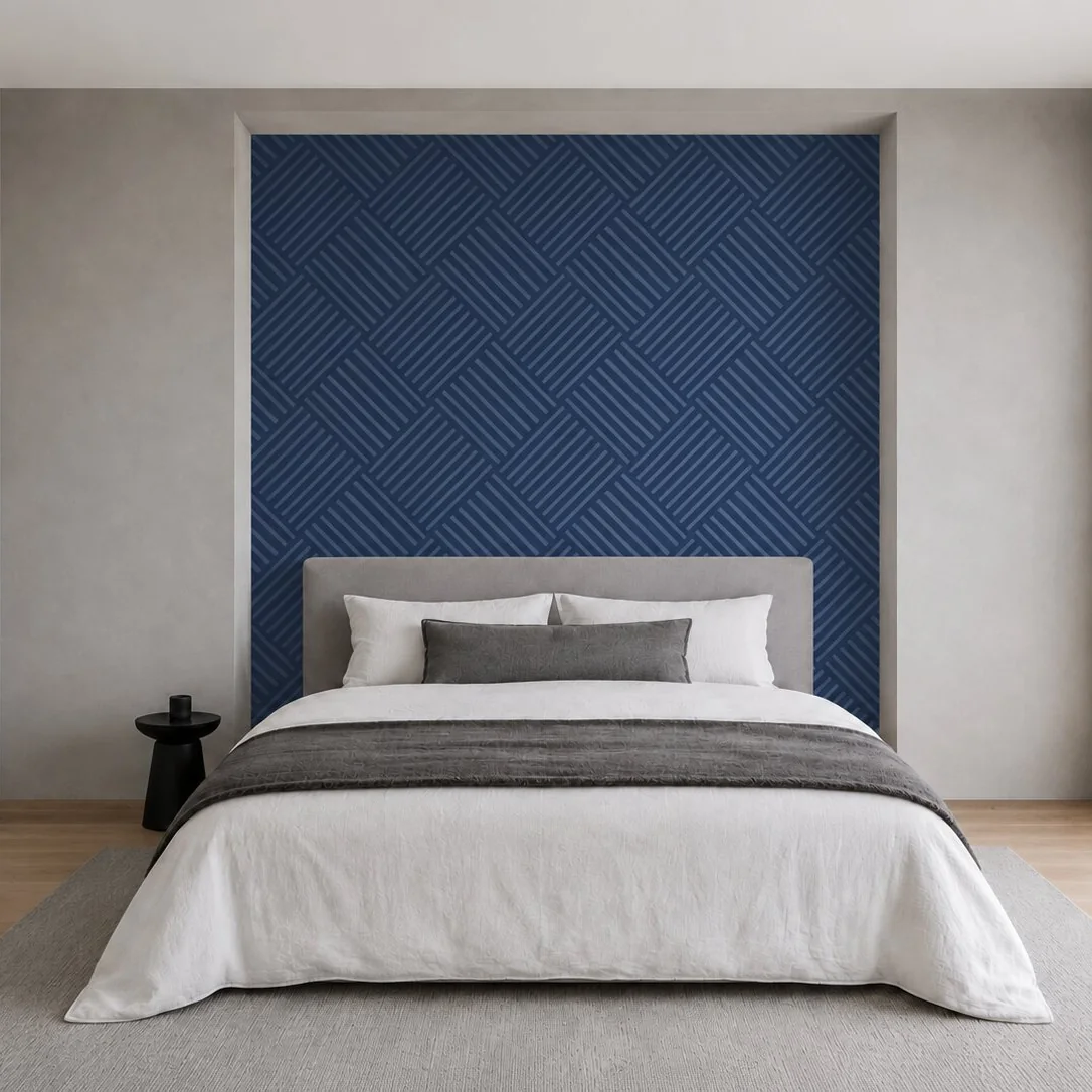 Bedroom alcove in navy wallpaper carrying the pattern