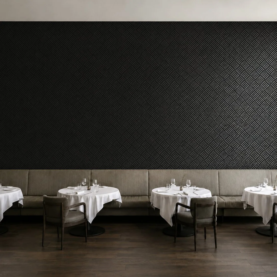 Restaurant wall upholstered in black textile carrying the pattern
